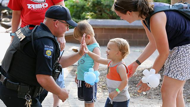 警察 officer chatting with 你ng children visiting campus